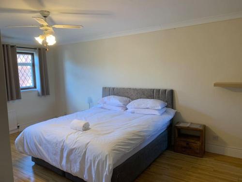 a bedroom with a bed with white sheets and pillows at Super King Bed Suite, Executive office, fast WiFi, free parking in St Ives