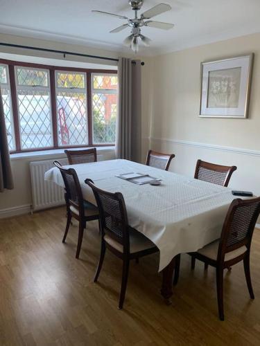 a dining room with a white table and chairs at Super King Bed Suite, Executive office, fast WiFi, free parking in St Ives