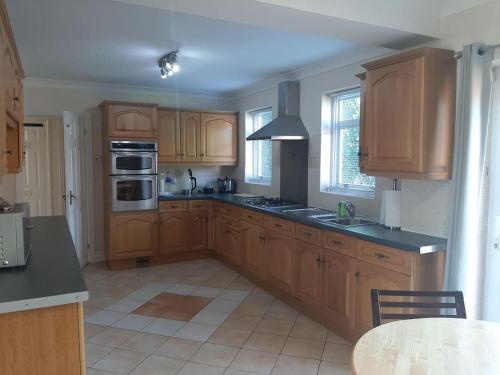a kitchen with wooden cabinets and a black counter top at Super King Bed Suite, Executive office, fast WiFi, free parking in St. Ives