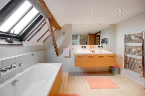 a bathroom with two sinks and a large bath tub at Luxury, countryside barn conversion with Hot tub in Kent