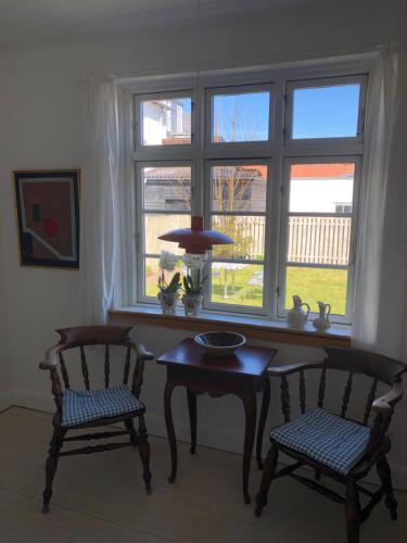 a living room with two chairs and a table and a window at Havnevej 18, stuen, Ballen in Ballen