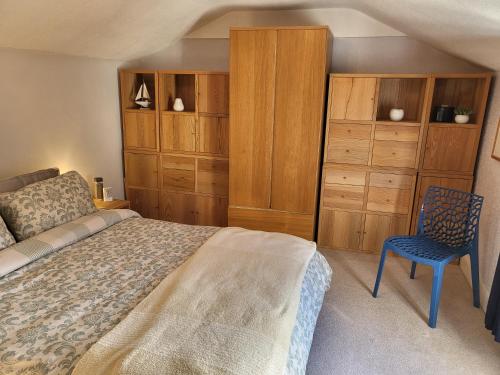 um quarto com uma cama, uma cadeira e armários de madeira em Executive Central Apartment - AR em Southport