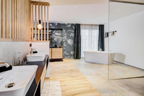 a bathroom with two sinks and a bath tub at Königswieser Hof in Königswiesen