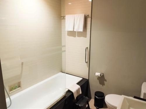 雅加達的住宿－AONE酒店，带浴缸和卫生间的浴室。