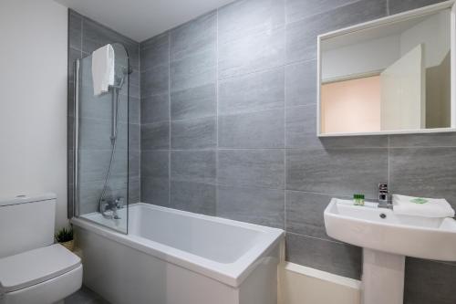 een badkamer met een wastafel, een bad en een toilet bij Fabulous Quayside Apartment with Free Parking in Liverpool