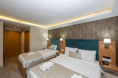 a hotel room with two beds with towels on them at Hotel Devman in Istanbul