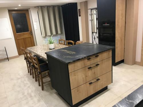 kuchnia z wyspą z czarnym blatem w obiekcie Paisible logement tout équipé pour 1 à 6 personnes w mieście Ebersheim