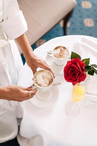 a bride and groom drinking coffee at a table at Primoretz Grand Hotel & Spa in Burgas City