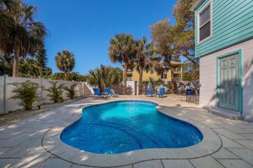 a swimming pool in a yard next to a house at Coquina Cottage B home in Anna Maria