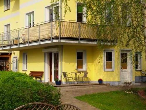 Casa amarilla con balcón y patio en Ferienwohnung Bergstraße 04 Whg 02, en Ahlbeck