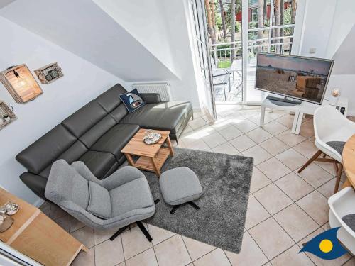 a living room with a couch and a tv at Fraeulein Loddin Whg_ Hugo in Kolpinsee