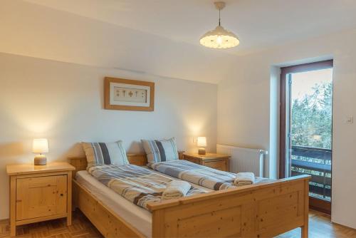 ein Schlafzimmer mit einem Holzbett mit zwei Nachttischen in der Unterkunft Villa Belica in Bohinj