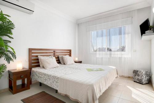 a white bedroom with a bed and a window at Bungalow Paraiso in Playa Blanca