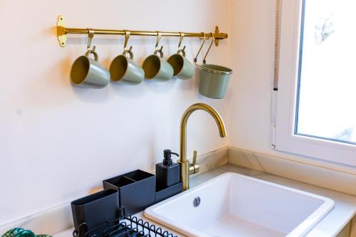 a kitchen with a sink and a bunch of pots and pans at Apartamentos Gaviota in Valencina de la Concepción