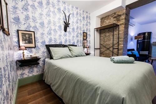 1 dormitorio con 1 cama grande y papel pintado de color azul y blanco en Apartamentos Gaviota, en Valencina de la Concepción