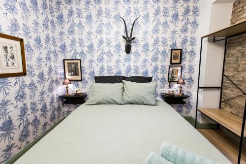 a bedroom with a bed with blue and white wallpaper at HN Gaviota in Valencina de la Concepción