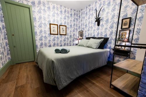 a bedroom with a bed with blue and white wallpaper at HN Gaviota in Valencina de la Concepción
