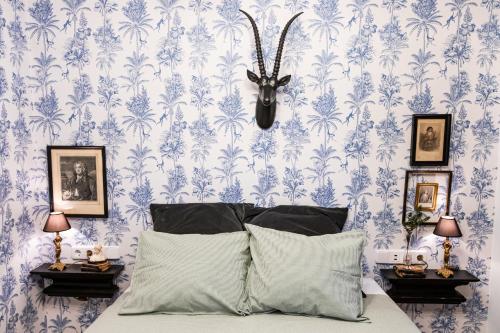 a bedroom with blue floral wallpaper and a bed with a headboard at HN Gaviota in Valencina de la Concepción