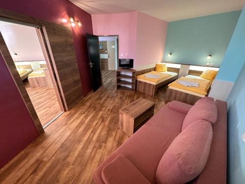 a living room with a couch and a room with a bed at Hotel N in Znojmo