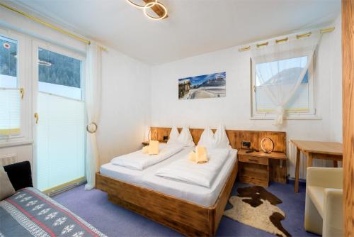 a bedroom with two beds and a table and a desk at Landhaus Josefa in Flachau