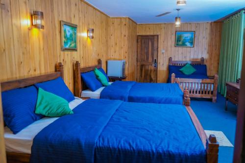 sypialnia z 2 łóżkami i niebieską pościelą w obiekcie Blue Moon Residency w mieście Nuwara Eliya