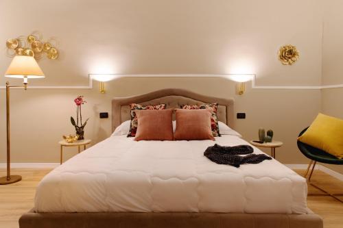 - une chambre avec un grand lit blanc et des oreillers orange dans l'établissement Fair Suite Roma Termini, à Rome