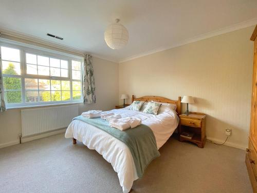 Schlafzimmer mit einem Bett und einem Fenster in der Unterkunft Spacious 4 Bedroom House with Garden and Parking in Ecclesall