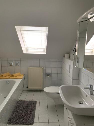 a bathroom with a sink and a tub and a toilet at Ferienwohnung nördliches Münsterland in Greven