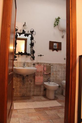 a bathroom with a sink and a toilet and a mirror at Trilocale nel centro storico in Montemerano