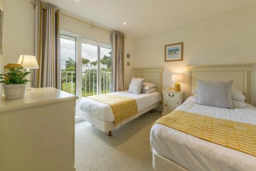 une chambre avec deux lits et une fenêtre dans l'établissement West Bay Cottages Yarmouth Isle of Wight, à Yarmouth