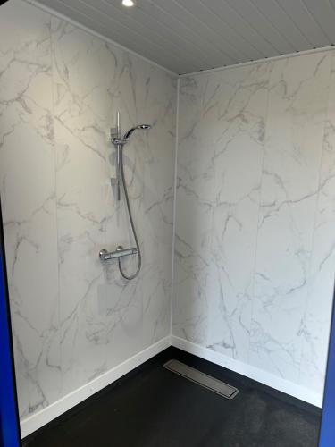 um chuveiro na casa de banho com paredes em mármore branco em Kaleb The Combine em Boston