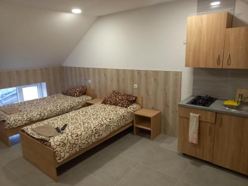 a room with two beds and a table and a kitchen at ROOMS FOR RENT in Panevėžys