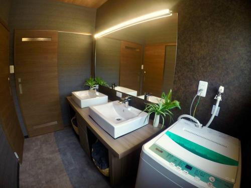 een badkamer met 2 wastafels en een grote spiegel bij Linore in Ginowan