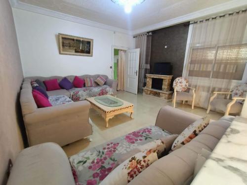 a living room with a couch and a table at S+2 skanes RDC enozha in Monastir