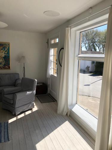 a living room with a couch and a large window at Havnevej 18, stuen, Ballen in Ballen