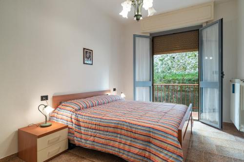 ein Schlafzimmer mit einem Bett und einem großen Fenster in der Unterkunft Appartamento Elisa 100 metri dal mare in Finale Ligure