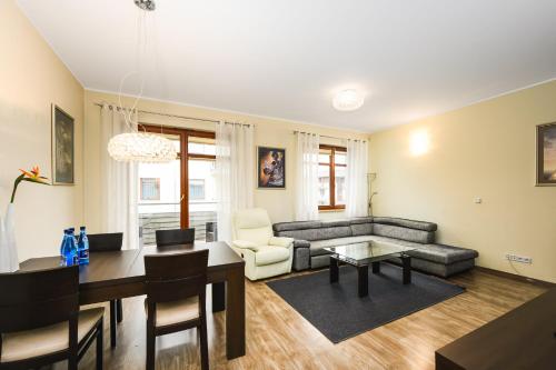 salon z kanapą i stołem w obiekcie Brownie - Neptun Park by OneApartments w Gdańsku