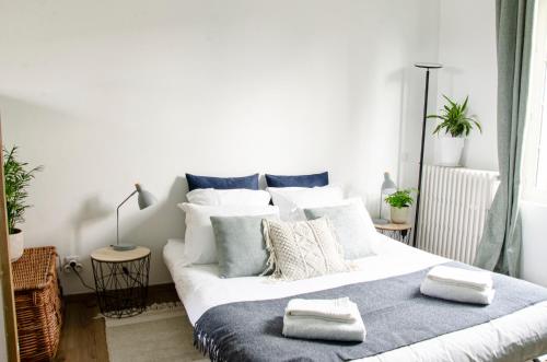 Un dormitorio con una gran cama blanca con almohadas. en Au 41 - le calme à 5 min d'Auxerre en Saint-Georges-sur-Baulche