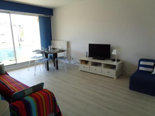 un salon avec un canapé, une télévision et une table dans l'établissement Studio en Centre-Ville d'Arcachon avec Balcon, Parking Privé et Wi-Fi, à 300m de la Plage - FR-1-374-28, à Arcachon