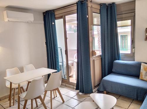 Zimmer mit einem Tisch und Stühlen sowie einem Bett und einem Fenster in der Unterkunft Résidence Graziella Studio 301 in Juan-les-Pins