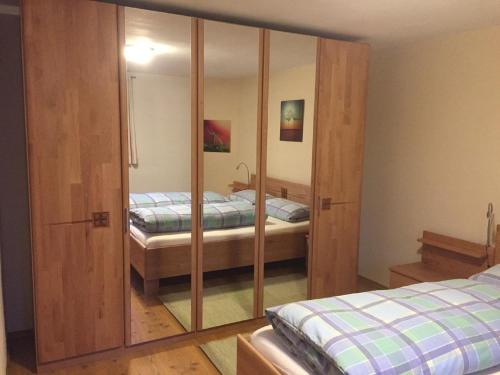 um quarto com 2 camas e um armário espelhado em FW Rettenberger em Rinchnach