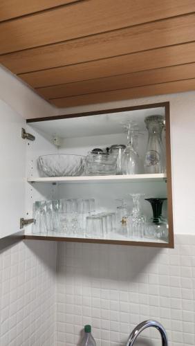 ein Küchenregal mit Gläsern und Geschirr in der Unterkunft Allgäunest in Leutkirch im Allgäu