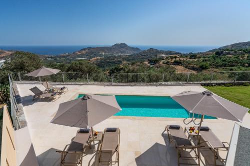 a swimming pool with chairs and umbrellas at Aloni Villa with 180° SeaView, Private Pool & BBQ, 2km from Beach in Plakias