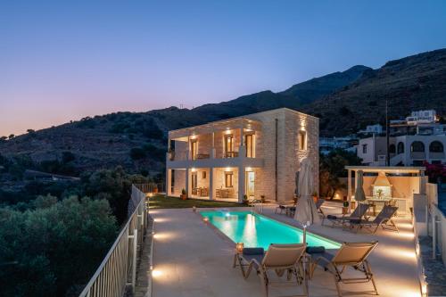 a villa with a swimming pool at night at Aloni Villa with 180° SeaView, Private Pool & BBQ, 2km from Beach in Plakias