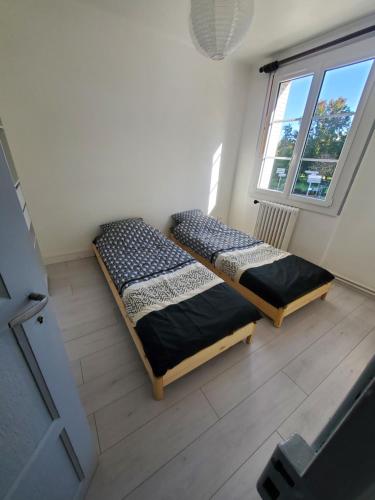 2 camas en una habitación con ventana en Maison au pied du château, en Châteaudun