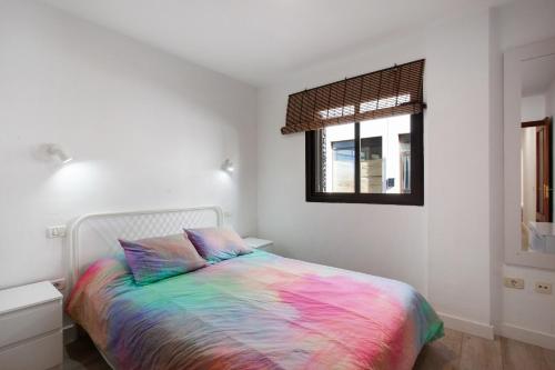 a bedroom with a bed with a colorful blanket at Apto Aguacada in Punta del Hidalgo