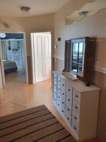 a bathroom with a dresser with a sink and a mirror at Maisonettewohnung Strandburg in Lubmin