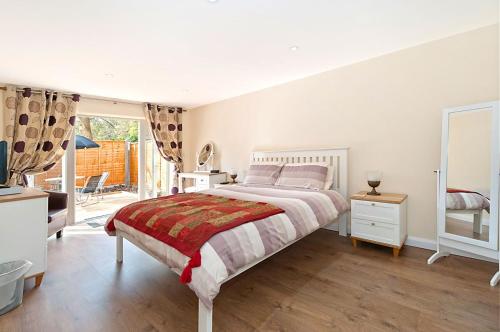Dormitorio blanco con cama y ventana grande en Potting Shed en Shadoxhurst