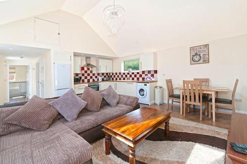a living room with a couch and a table at Potting Shed in Shadoxhurst