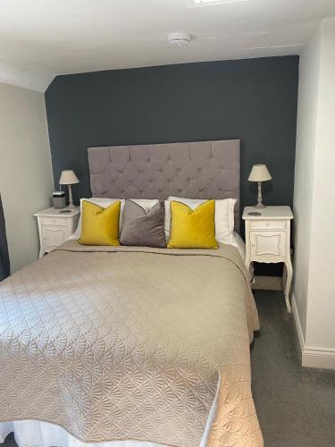 a bedroom with a large bed with yellow pillows at B&Bat no3 in Market Bosworth